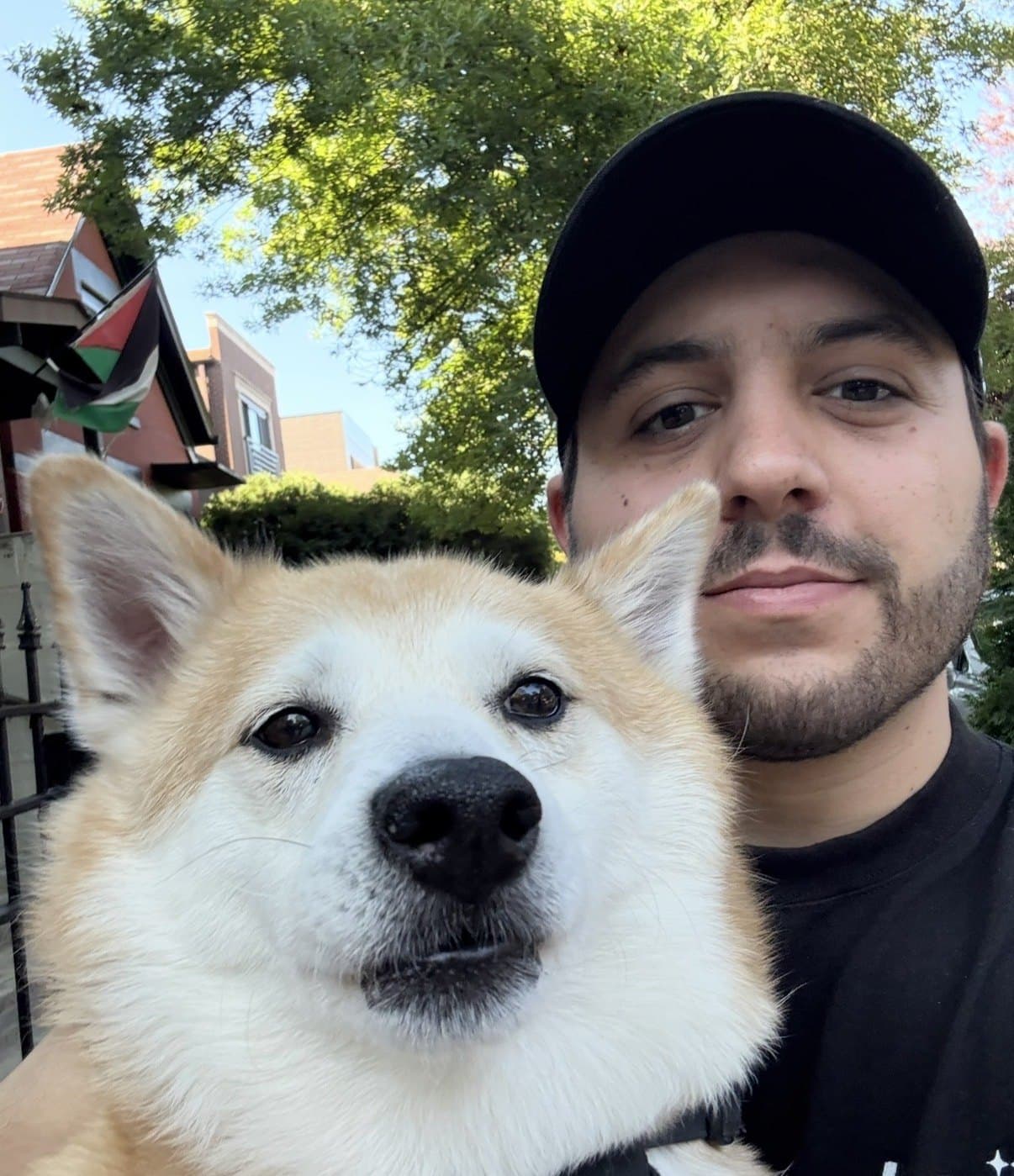 ScadMeta with his dog ScadMeta (@ScadMeta) in a black cap taking a selfie with a tan and white dog